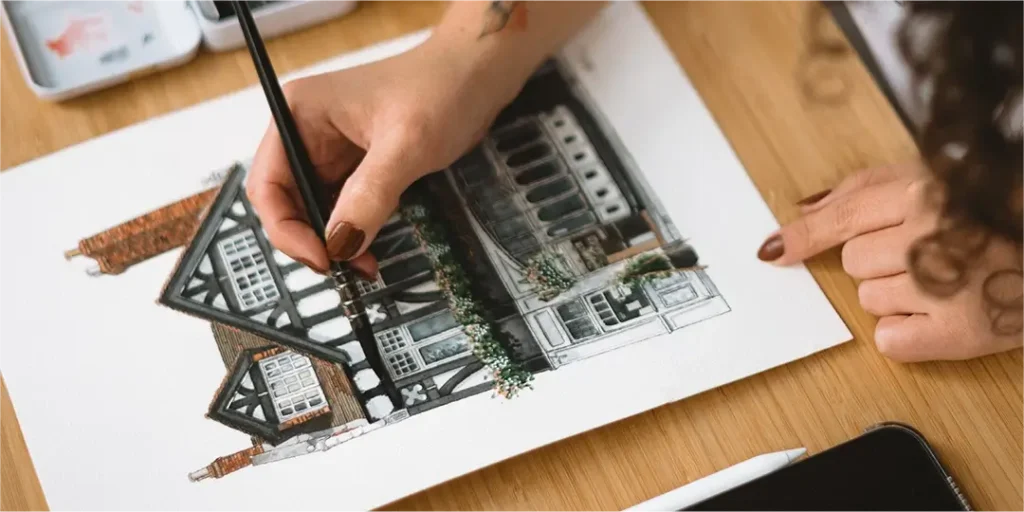 Marina Assis’s hand painting a building in watercolour, showcasing architectural art