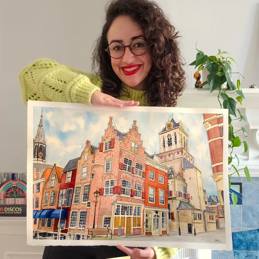 Marina Assis holding a large watercolor painting of a corner with buildings in London